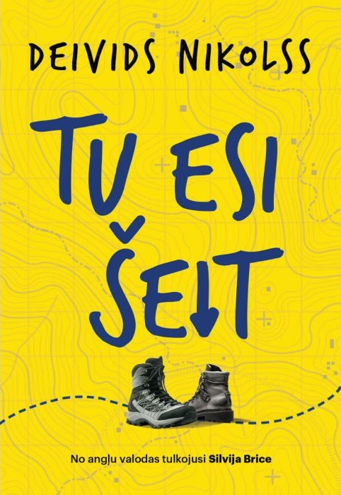 Spilgti dzeltens grāmatas vāks ar treknrakstā zilu tekstu "Tu Esi Šeit". Apakšdaļā attēloti divi pārgājiena zābaki. Fona attēls ir ar topogrāfiskās kartes līnijām.