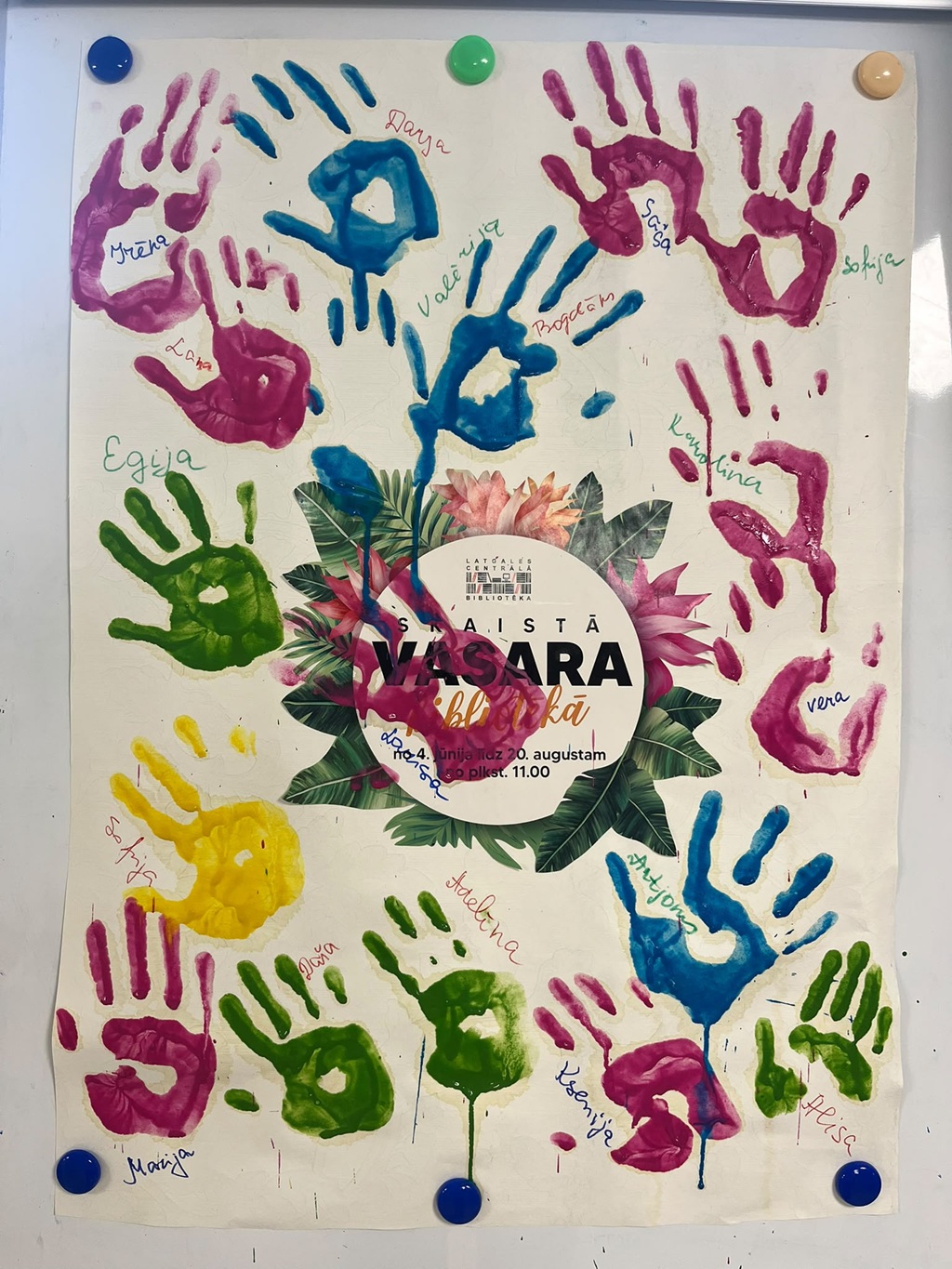 Programmas "Skaistā vasara bibliotēkā" plakāts ar bērnu krāsainajiem plaukstu nospiedumiem