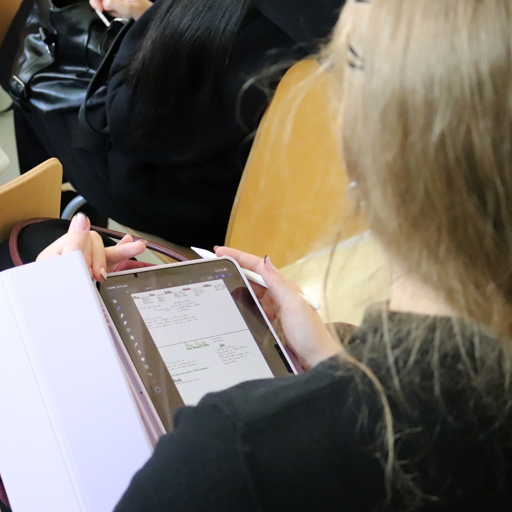 Apmeklētāja veic piezīmes planšetdatorā pasākuma laikā