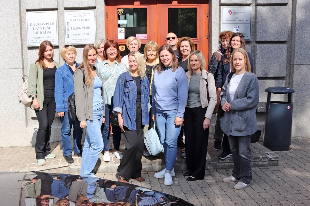 Ekskursijas dalībnieku kopbilde pie bibliotēkas ieejas.