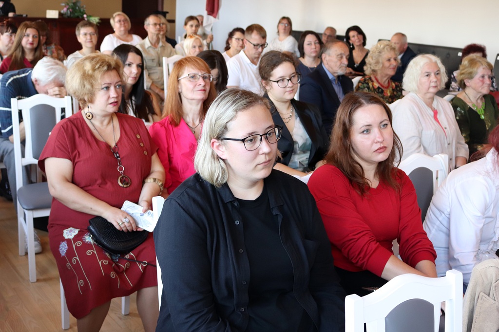 Daudzskaitlīga auditorija pildītā zālē uzmanīgi seko līdzi pasākuma norisei