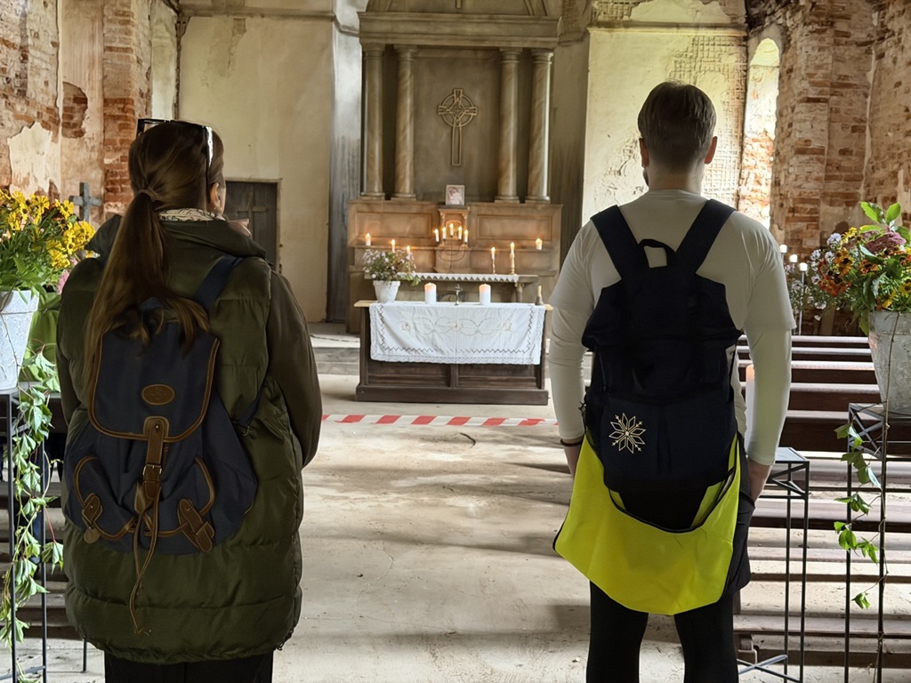 Divi cilvēki vecajā Birķineļu luterāņu baznīcā pie altāra